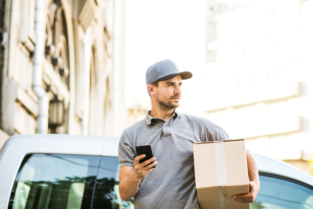 new-shutterstock_1120248758 courier using mobile phone